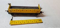 Side view of yellow Lionel gondola car with detached side panel