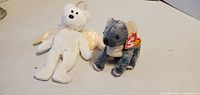White bear with wings and grey koala plush side by side