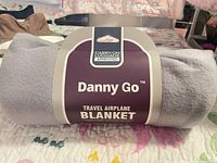 Rolled Danny Go blanket with branded sleeve front view