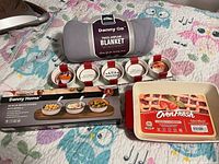 All items laid out: blanket, ramekins, boxed board with bowls, baking dish
