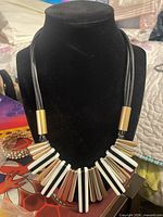 Full view of necklace on bust showing bib design and cords