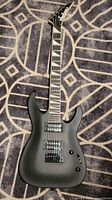 Full view of matte black Jackson electric guitar body and neck
