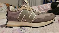 Left side view of one sneaker showing suede, mesh, logo, outsole