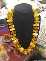 Full view of necklace on stand showing graduated yellow and amber beads