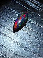 Top view of marquise black opal showing multicolored play-of-color