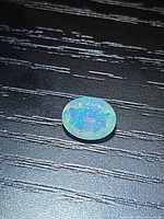 Top view of the oval faceted Ethiopian opal showing multicolour pinfire pattern