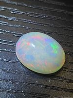 Top view of oval cabochon opal showing multicolour play-of-colour