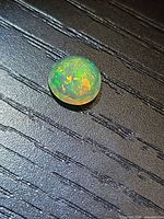 Round faceted opal showing multicolor flashes