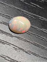 Top view of oval cabochon opal showing play-of-color