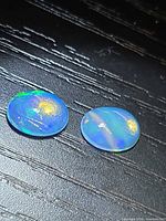 Both oval opals showing body color and play-of-color
