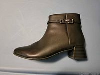 Left profile of black leather ankle boot showing decorative strap and block heel