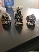 Three gothic rings standing: two skulls and one Grim Reaper