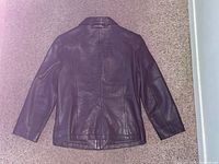 Back view of black leather jacket showing overall condition and seam lines