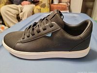 Left side view of right sneaker showing black synthetic upper and white sole