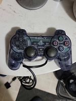Front view of translucent DualShock 2 controller showing buttons and analog sticks
