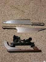 Two floral engraved knives and disassembled stand laid out