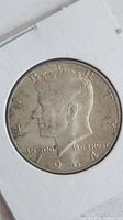 Obverse of 1964 Kennedy half dollar in holder