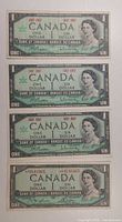 Fronts of four 1967 Canadian $1 notes showing serial/date differences