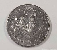 Reverse side of 1970 Manitoba Centennial dollar coin showing prairie crocus design and inscriptions