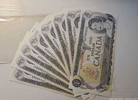 Fan display of eight 1973 $1 Bank of Canada notes showing obverse side and serial numbers