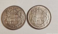 Two 1958 Canadian 50-cent coins, reverse side with coat of arms visible