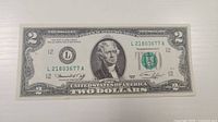 Obverse of $2 note showing portrait, serial number L21803677A and green seal