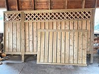 Two fence panels: large lattice-top panel with posts, smaller plain panel leaning