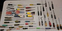 All tools laid on table showing screwdrivers, pliers, picks, scraper