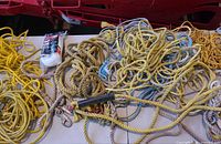 Overview of multiple coils of yellow and beige rope, packaged rope, assorted hardware