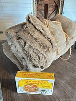 Decorator set box with burlap roll side by side on table