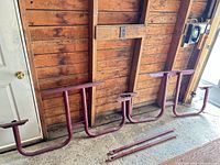 Overall view of three burgundy steel leg frames and two crossbars