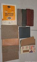 Group of sandpaper sheets, strips and packages laid out
