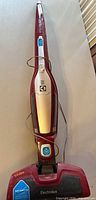 Full view of red Electrolux Ergorapido stick vacuum lying flat