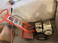 Full view of Gilson rototiller showing frame, engine, tires, and tines