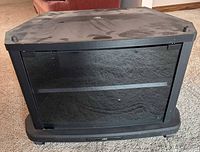 Front view of black JVC TV stand with smoked glass door closed