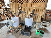 Overall lot showing tools in two white bins, hand tools, spreaders, decor pieces and crate
