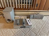 Full lot showing DVD/VCR unit, subwoofer, five satellites, center speaker, remotes, manual