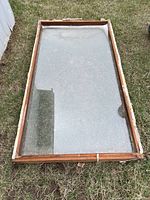 Full view of wood framed single pane window sash lying on grass