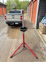 Entire repair stand showing red tripod legs, silver mast, clamp, parts tray