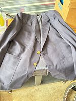 Full view of blazer front showing color, two buttons, lapel, pockets