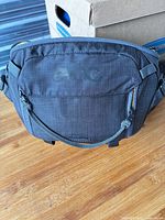 Front view showing Evoc logo, zippered pocket, shape and fabric