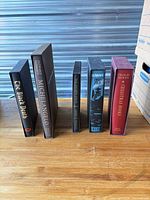 All five Folio Society books lined upright with slipcases visible