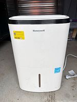 Front view of dehumidifier showing brand logo, Energy Star sticker, water tank window, power cord