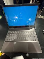 Laptop powered on at login screen, keyboard visible