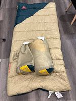 Unrolled tan ⁄ teal Kelty Catena sleeping bag with both stuffed bags on top
