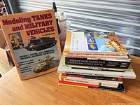 Stack of modelling and military history books beside Modeling Tanks and Military Vehicles book