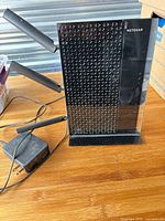 Full view of range extender standing upright with three antennas and power adapter