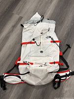 Front view of white Phantom 50 backpack showing main body, hip belt, compression straps, and brand logo
