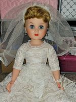 Front view of bride doll seated showing full gown, veil, facial features