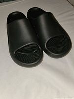 Pair of black Crocs slides angled view